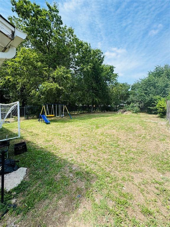 view of yard with a fenced backyard and a playground