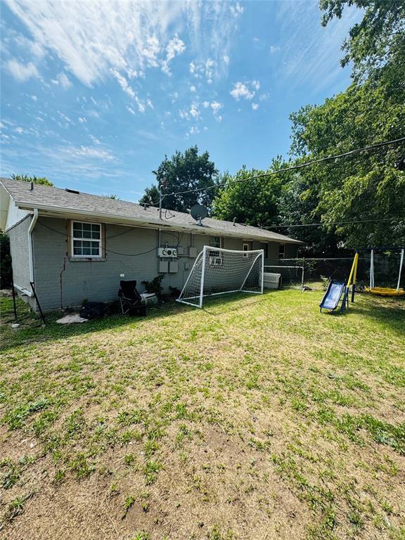 back of property with fence and a lawn