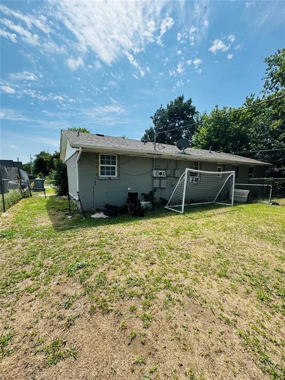 back of house featuring fence and a lawn