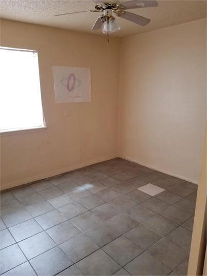 empty room featuring ceiling fan and a textured ceiling