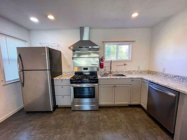 kitchen with light stone counters, stainless steel appliances, dark wood-type flooring, sink, and wall chimney range hood