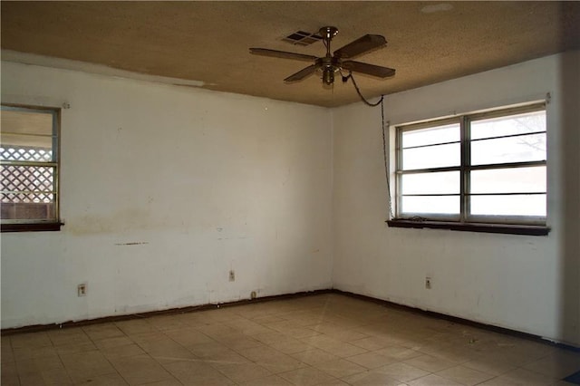 empty room with a textured ceiling and ceiling fan