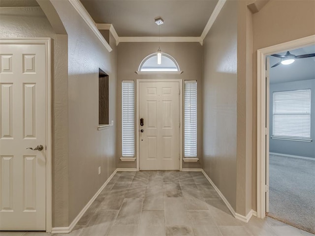 entryway featuring baseboards, ornamental molding, and arched walkways