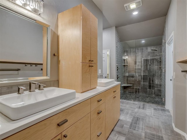 bathroom with double vanity, a stall shower, visible vents, and a sink