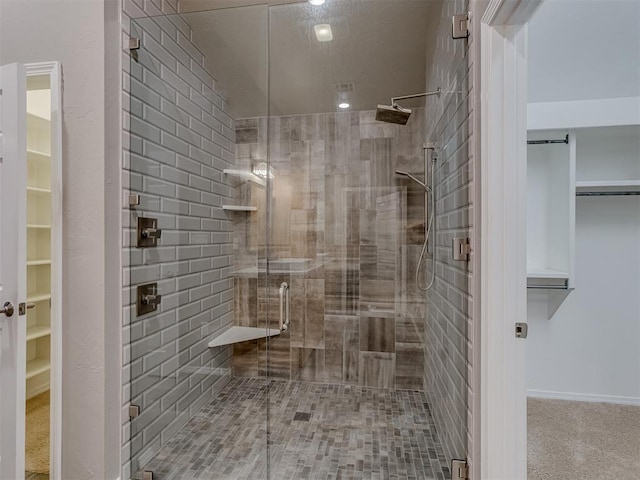 full bathroom with a stall shower and a spacious closet