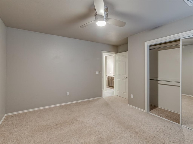 unfurnished bedroom featuring a ceiling fan, a closet, light colored carpet, and baseboards