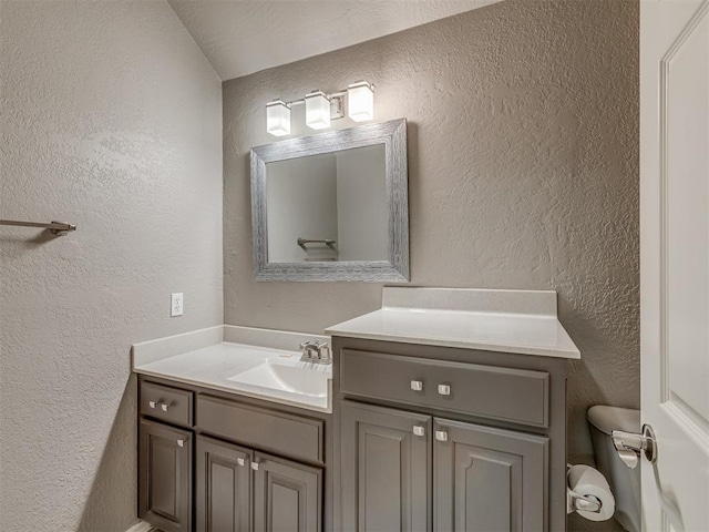 bathroom featuring a textured wall and vanity