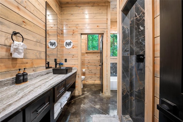 bathroom featuring wooden walls, vanity, and toilet