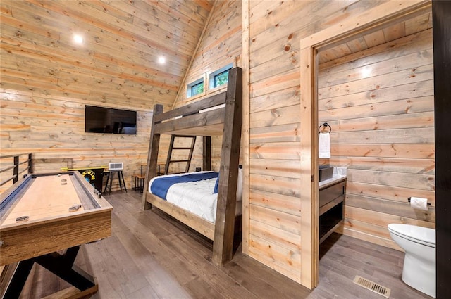 bedroom with hardwood / wood-style floors, high vaulted ceiling, wooden ceiling, and wood walls