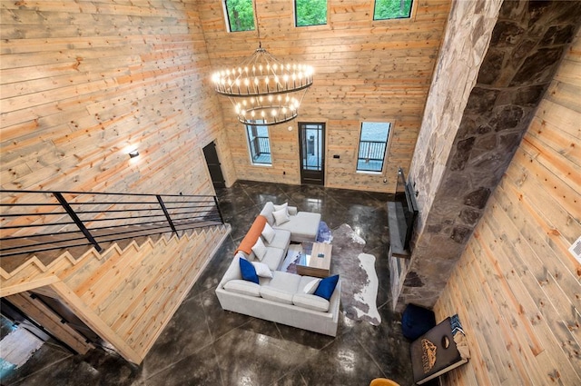 interior space with wood walls, a chandelier, and a high ceiling