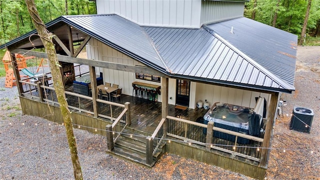 exterior space with cooling unit, a deck, and metal roof