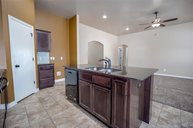 kitchen featuring light colored carpet, ceiling fan, sink, a center island with sink, and black dishwasher