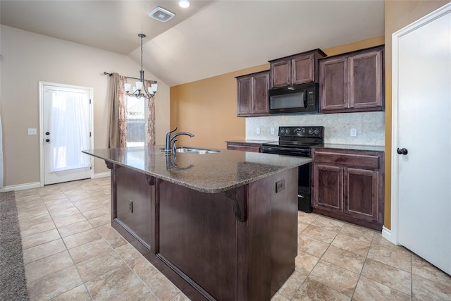 kitchen with lofted ceiling, backsplash, an inviting chandelier, black appliances, and an island with sink