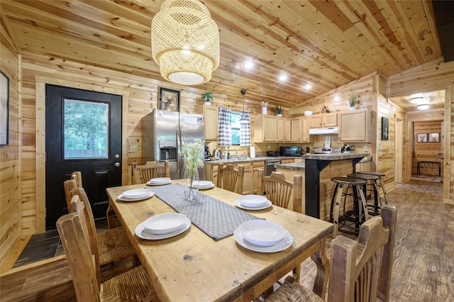 dining room featuring dark hardwood / wood-style floors, wood walls, lofted ceiling, and a wealth of natural light