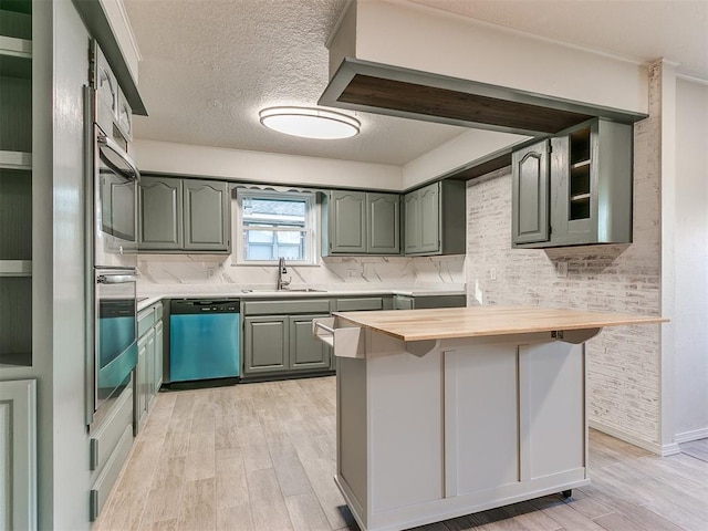 kitchen with butcher block countertops, dishwasher, light wood-type flooring, and sink