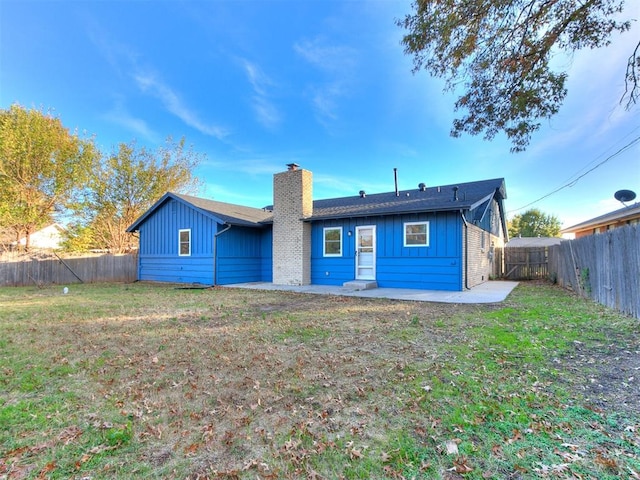 rear view of house with a patio and a lawn