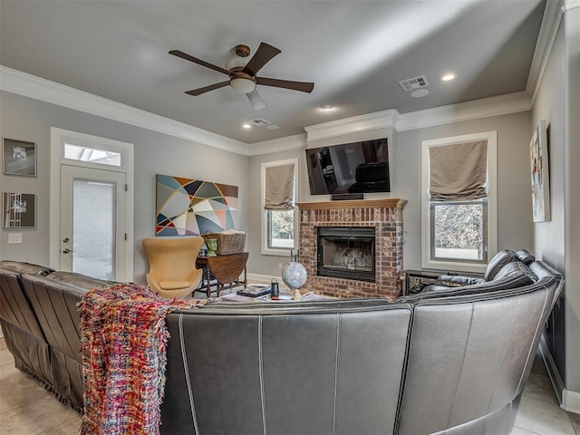 living room featuring a fireplace, light tile patterned floors, ceiling fan, and ornamental molding