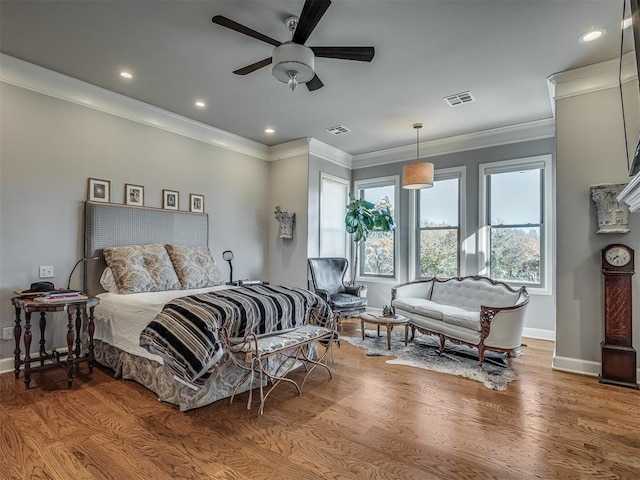 bedroom featuring hardwood / wood-style flooring, ceiling fan, and crown molding