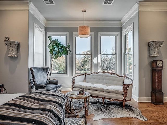 living area with hardwood / wood-style floors and ornamental molding