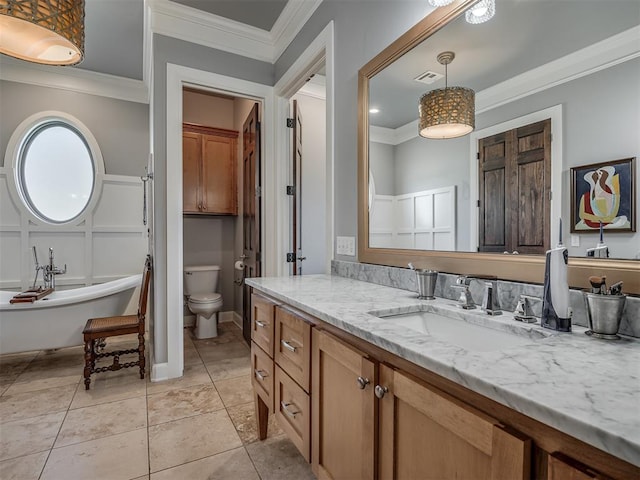 bathroom featuring tile patterned floors, vanity, crown molding, toilet, and a tub