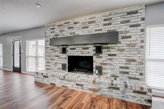 room details featuring wood-type flooring and a brick fireplace