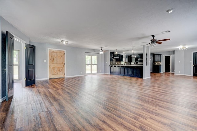 unfurnished living room with hardwood / wood-style flooring and ceiling fan