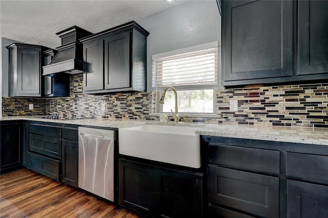 kitchen with backsplash, dark hardwood / wood-style flooring, stainless steel dishwasher, and sink