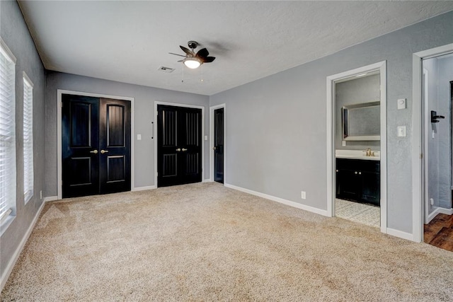 unfurnished bedroom with ceiling fan, carpet floors, sink, and connected bathroom