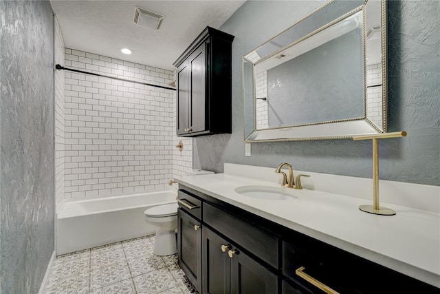 full bathroom featuring tile patterned flooring, vanity, tiled shower / bath combo, and toilet