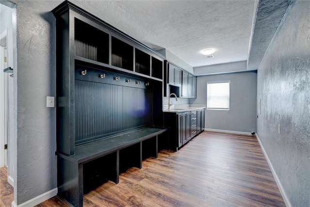 mudroom with a textured ceiling, dark hardwood / wood-style floors, and sink