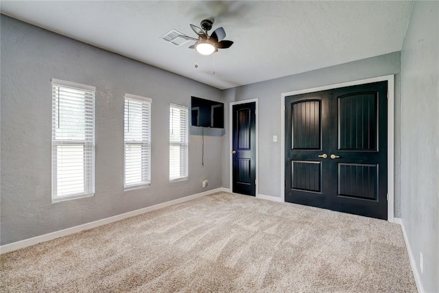 unfurnished bedroom with ceiling fan, a closet, and carpet floors