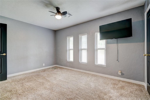 carpeted spare room with ceiling fan