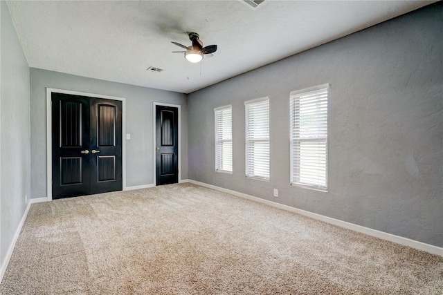 unfurnished bedroom featuring ceiling fan and carpet