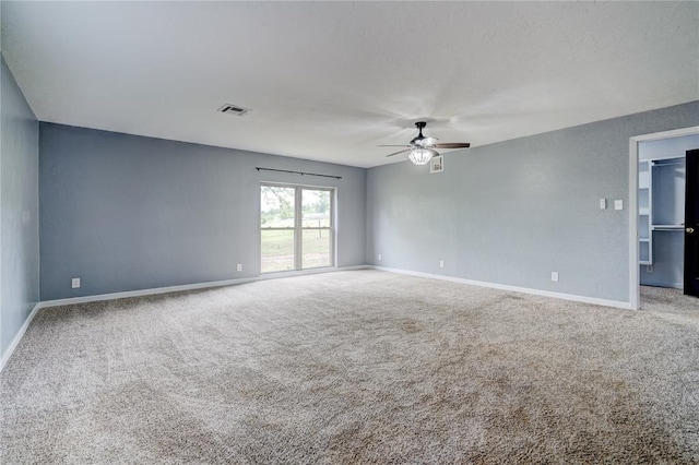 carpeted spare room featuring ceiling fan