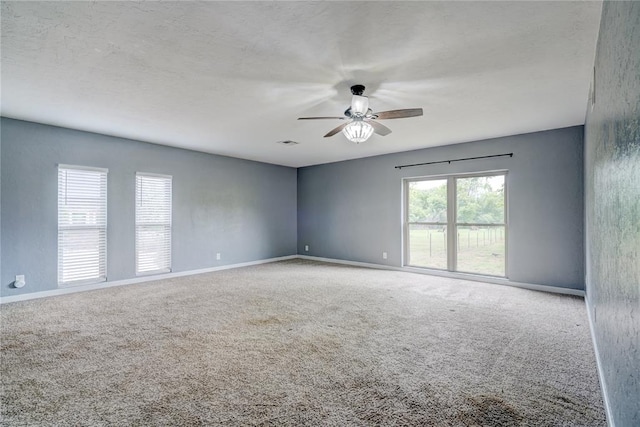 carpeted empty room featuring ceiling fan