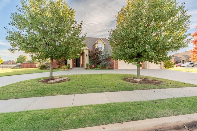 view of property hidden behind natural elements with a front lawn and a garage