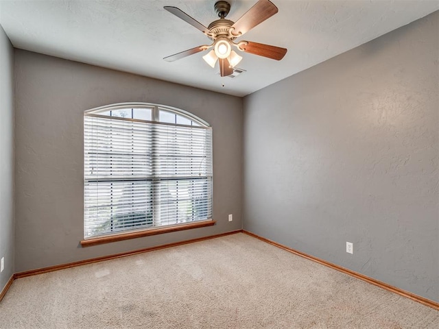 spare room with carpet and ceiling fan