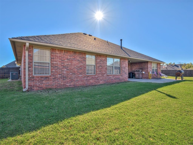 rear view of property with a yard, a patio, and cooling unit