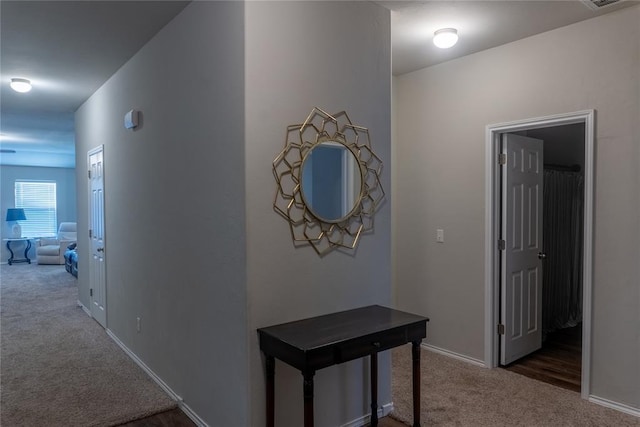 hallway with dark colored carpet