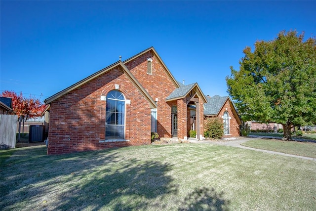 view of front of home with central AC and a front lawn