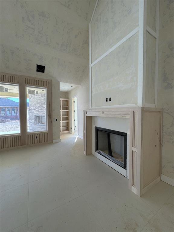 unfurnished living room with a towering ceiling