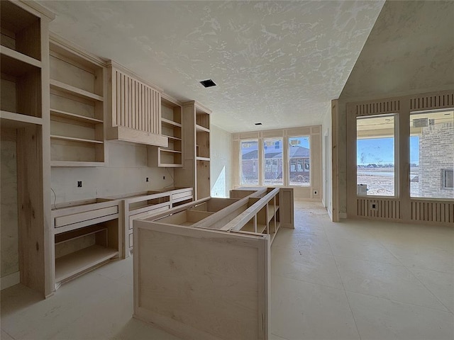 kitchen with a textured ceiling, light tile patterned floors, and light brown cabinets