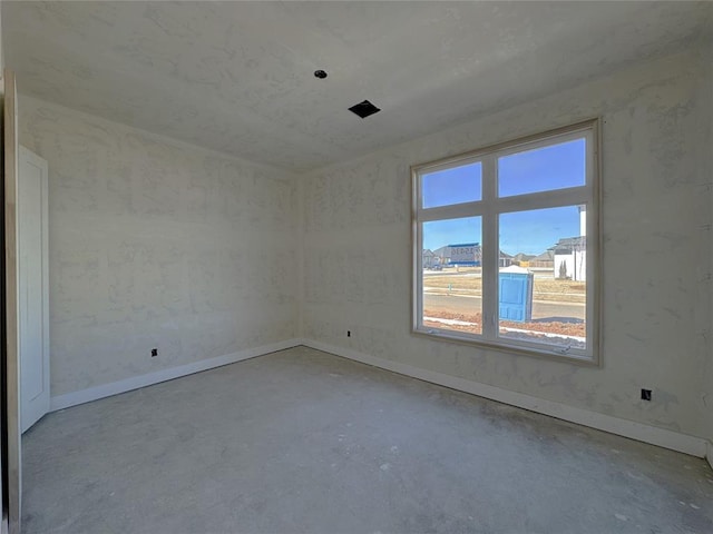 empty room with a wealth of natural light and concrete floors