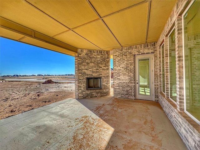 view of patio featuring an outdoor brick fireplace