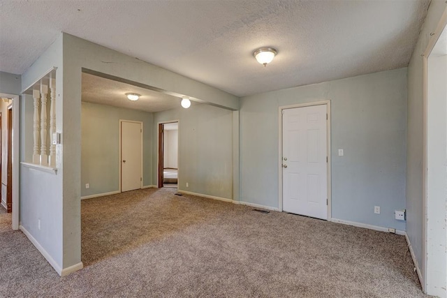 spare room featuring carpet and a textured ceiling