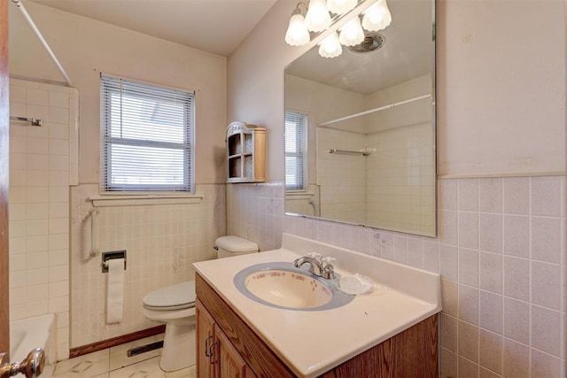 bathroom with vanity, tile walls, and toilet