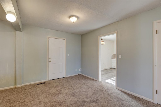 carpeted spare room with a textured ceiling