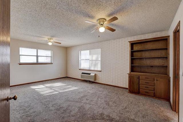 carpeted empty room with a wall mounted air conditioner, a textured ceiling, and ceiling fan