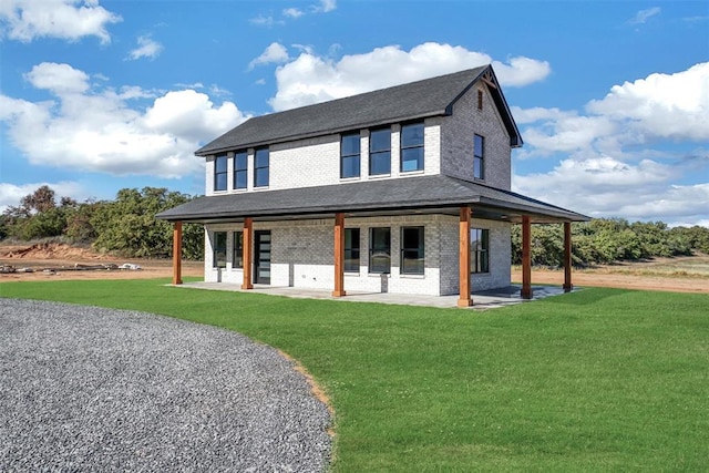 farmhouse inspired home with a front lawn and a patio area