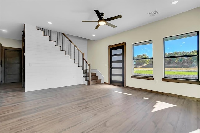 unfurnished living room with ceiling fan and hardwood / wood-style flooring